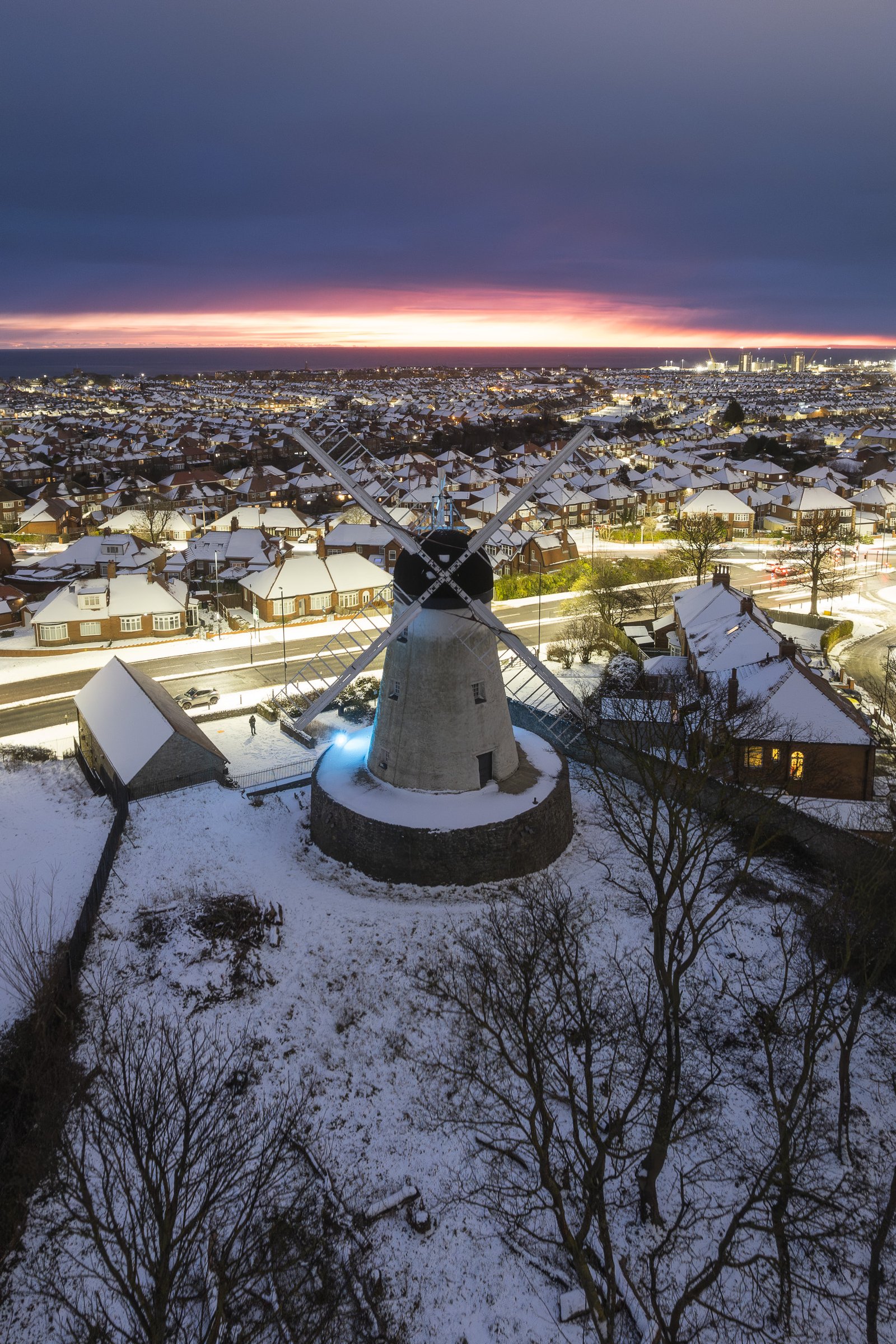 Aerial view of Fulwell Mill at dusk with snow on the ground